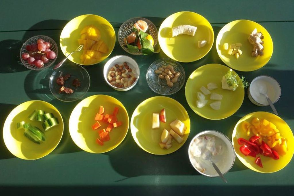 Viele unterschiedlich große Schüsseln gefüllt mit klein geschnittenem Obst, Gemüse und Nüssen 