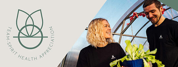 Menschen im Gewächshaus mit Pflanze